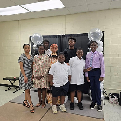 Sis. A'Ishah Karriem of Muhammad Mosque 102 with her piano students after recital